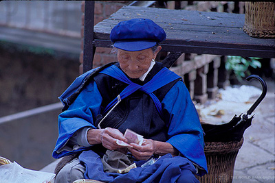 Una mujer mayor cuenta el dinero en China.